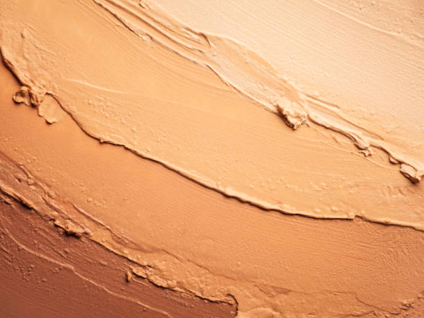 Various shades of foundation cream are swirled together, illustrating the range of colors available for selection.